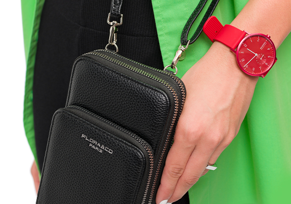 Schwarze Handtasche von Flora & Co und rote Uhr