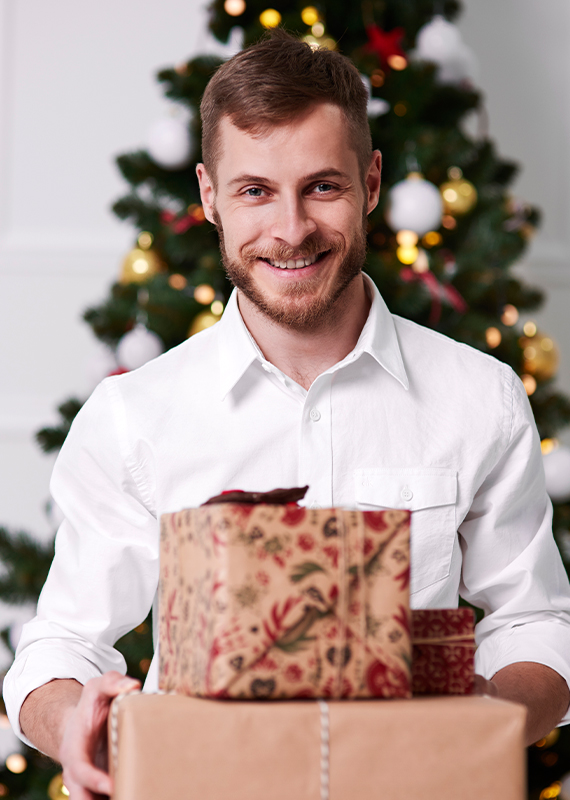 muž v bílé košili s vánočními dárky