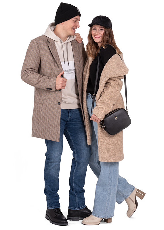 ein Paar im Winteroutfit, eine Dame mit einer Cap Heavy Tools, ein Mann im Mantel Jack&Jones